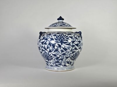 un vase bleu et blanc muni d'un couvercle, posé sur une table