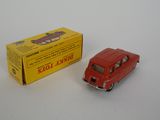 a red toy car next to a yellow box on a white surface