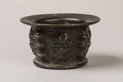un vase noir orné d'un motif sur fond blanc