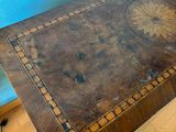 a table with a wooden top on a hard wood floor