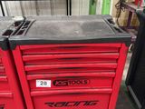 une boîte à outils rouge sur laquelle sont posés des outils, dans un garage