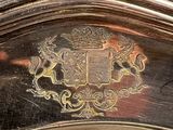 a close up of a silver plate with a coat of arms on it