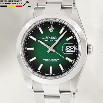 a rolex watch with a green dial on a bracelet