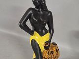 a statue of a woman sitting on top of a pile of bananas