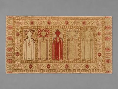 a rug with three women and two men standing in front of a blue background
