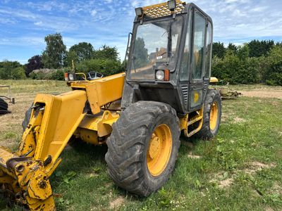 un tracteur jaune garé dans l'herbe