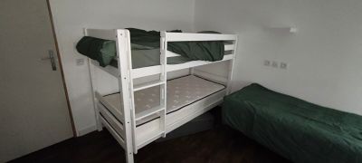 un lit superposé recouvert d'un drap vert
