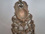 une horloge en argent posée sur une chaise en bois