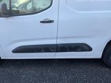 une camionnette blanche garée sur un parking à côté d'un bâtiment