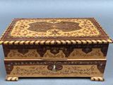 an ornate wooden box sitting on top of a blue surface