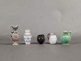 five small vases sitting next to each other on a table