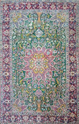 a green and red rug with a floral design on it