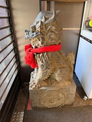 une statue représentant un chien avec un foulard rouge autour du cou
