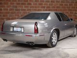 a silver car parked in a garage with a brick wall behind it