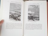 a person holding a book open on a table