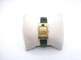 une photo d'une montre-bracelet en or avec un bracelet vert