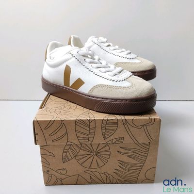 white and brown vejaa sneakers on top of a cardboard box