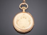 an antique gold pocket watch with a chain hanging from it ' s side