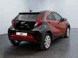 the rear of a red and black toyota c - hr parked in a room