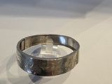 un gros plan d'une bague en argent posée sur une table