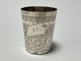 a silver cup with a tag on it sitting on a table