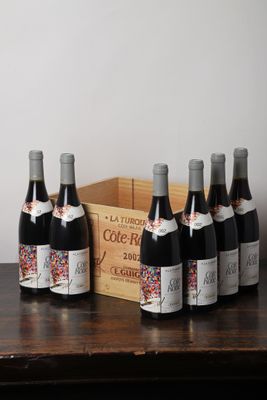 plusieurs bouteilles de vin posées sur une table à côté d'une caisse en bois