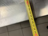 a measuring tape that is on the edge of a sink