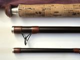 a close up of two fishing rods on a white surface