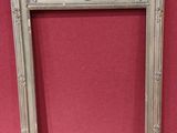 an ornate silver frame with a red wall in the background