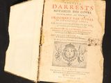 an old book that is open on a black surface