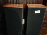two speakers sitting on top of a wooden floor next to each other