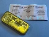 gold bar next to a ticket on a blue surface
