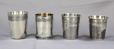 Quatre coupes en argent ornées de motifs sont alignées sur une table