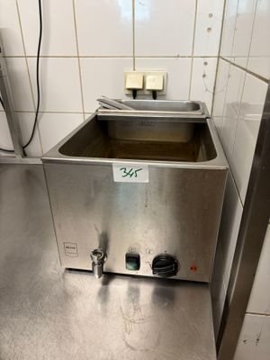 un évier en acier inoxydable dans une cuisine aux murs carrelés