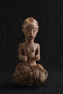 l'image d'une statue de femme assise au sommet d'un rocher