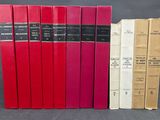 quatre livres rouges sont alignés sur une surface noire