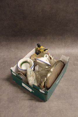 une boîte posée sur une table, contenant une figurine de grenouille