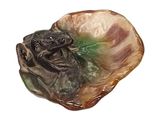 a figurine of a frog sitting on a shell