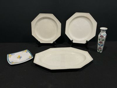 trois assiettes et un vase posés sur une table
