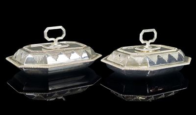 pair of silverplated butter dishes with lids on a black surface
