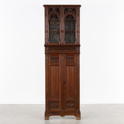 an old wooden cabinet with glass doors and a door on the top