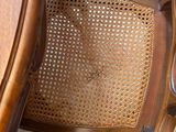 a wooden chair that has a rattan back and a cane back
