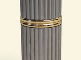 a silver container with a gold band around it