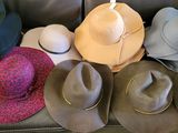 de nombreux chapeaux posés sur un canapé