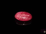 a close up of a red stone on a black surface
