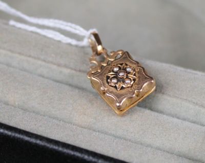 un petit pendentif en or orné d'une fleur