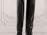 a pair of black boots sitting on top of a wooden table