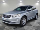 Le SUV Volvo argenté est garé sur un sol carrelé à damier.