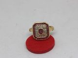 a close up of a gold ring with a ruby and diamond center