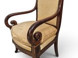 une chaise en bois avec une assise et des accoudoirs rembourrés de couleur beige